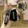 A hand holds a sleek black key cover with buick branding, featuring a leather strap and a detailed front design, showcasing t...