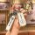 A hand holds a white nissan key cover with a sleek design, featuring the nissan logo and a matching keychain strap. the inset...