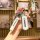 A hand holds a sleek mazda key cover set, featuring a white leather strap with mazda text and a metallic key fob case, showca...