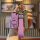 A hand holds a pink dongfeng venucia r50 key cover (2016 model) with a quilted leather strap and a numbered charm, set agains...
