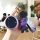 A hand holds a nezha v & u pro key cover, showcasing its sleek purple design with a circular control panel and a matching bea...