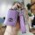 A hand holds a purple mazda 3 key cover with a quilted leather strap and a diamond-encrusted keychain, showcasing a sleek and...