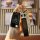 A hand holds a sleek, foldable leather key fob cover for the buick excelle (2022–2023), featuring a black design with silver ...