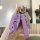 A hand holds a purple b70 key cover for the 2022 faw besturn, featuring a sleek design with a diamond-patterned strap and a d...