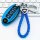 Blue leather key cover for infiniti q50l 2021, featuring a braided design and car logo charm, displayed on a keyboard.