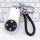 Silver nio es8 key cover with black leather strap, featuring a sleek design and functional buttons, displayed on a keyboard b...