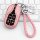 Elegant pink leather maserati key cover for levante & ghibli, featuring a braided strap and sleek design, displayed on a keyb...