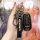 A hand holds a sleek infiniti key cover, featuring a premium leather strap with the infiniti logo and a matching key fob, des...
