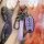 A hand holds a nissan key fob encased in a purple leather cover, featuring a sleek design with buttons labeled hold and icons...