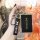 A hand holds a sleek xiaomi-powered xiao peng p7 key cover, featuring a black leather strap with peng text and a metallic tag...