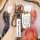 A hand holds a wuling hongguang mini ev key cover, featuring a sleek white design with a branded strap and functional buttons...