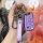 A hand holds a purple skoda key cover for models like octavia, superb, and yeti, featuring a leather strap with the skoda log...