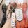 A hand holds a stylish lynk & co key cover for 03/01/02 (2022+), featuring a white design with a cute face illustration and a...