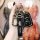 A hand holds a cadillac key fob encased in a sleek black leather cover, featuring the cadillac logo and a matching keychain, ...