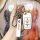 A hand holds a lufeng x2 smart key cover featuring a sleek white design with a metal clasp and a landwind branded strap, set ...