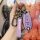 A hand holds a purple leather key cover for the changan suzuki vitara, featuring a sleek design with a suzuki logo and functi...