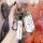 A hand holds a sleek, white ds-compatible aftermarket key cover for nissan, honda, and toyota, featuring a good luck strap an...