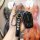 A hand holds a sleek black key cover for the jiangling isuzu mux dmax, featuring a metallic isuzu logo and a matching keychai...