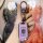 A hand holds a sleek, lavender buick verano pro key cover with a metallic clip and logo, set against a vibrant, artistic back...
