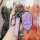 A hand holds a purple gac trumpchi key cover with a sleek design, featuring a car icon and lock/unlock symbols, accompanied b...