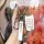 A hand holds a sleek white baojun key cover with a metallic finish, featuring a car key fob and a branded strap, set against ...
