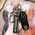A hand holds a sleek porsche key cover set, featuring a black leather strap with porsche text and a matching key fob, designe...