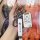 A hand holds a sleek white buick excelle key cover, featuring a carabiner and a branded strap, designed for 2008–2015 models....